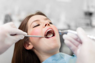 Woman receiving a dental treatment clipart