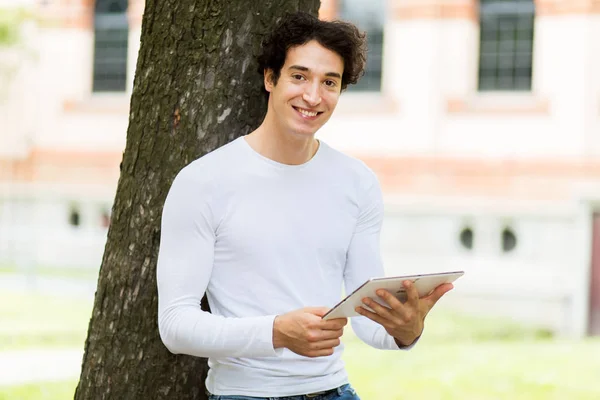 Ung Kille Som Använder Digital Surfplatta Stående Mot Ett Träd — Stockfoto