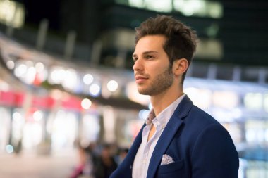Genç adam açık havada yürüyüş bir şehirde gece gülümseyen