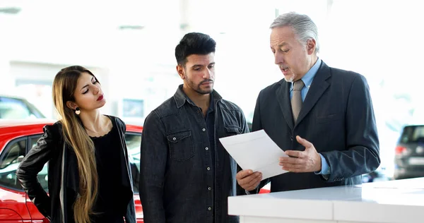 Car Dealer Reading Contract Couple Auto Showroom — Stock Photo, Image