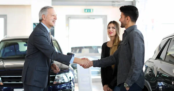 Bilhandlare Som Ger Ett Handslag Till Ett Ungt Par — Stockfoto