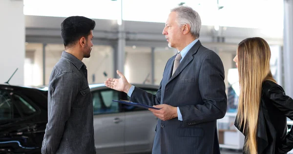 Car Dealer Explaining Car Features Couple Reading Document — Stock Photo, Image