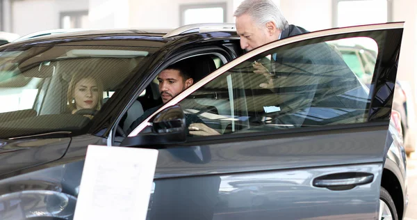 Jovem Casal Examinando Carro Novo Showroom — Fotografia de Stock