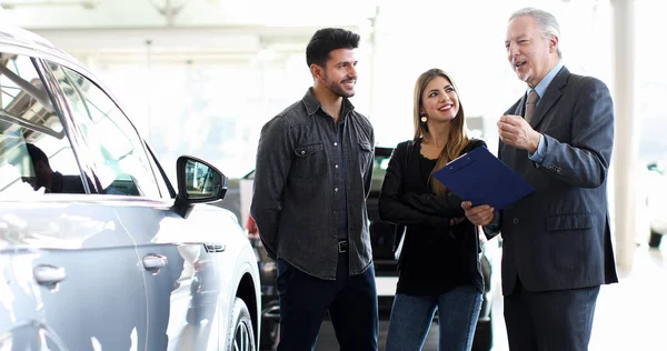 Car Dealer Explaining Car Features Couple Reading Document — Stock Photo, Image