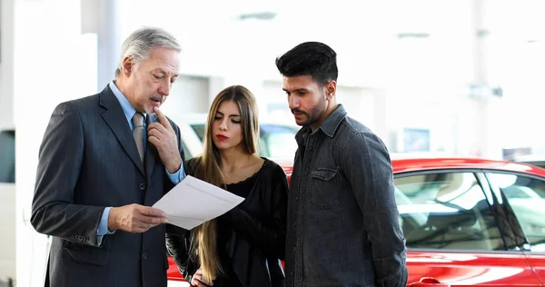 Dealer Auto Care Citește Contract Cuplu Într Showroom Auto — Fotografie, imagine de stoc