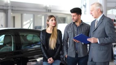Bir belge 4 k okuyarak bir çift için bir aracın özellikleri açıklayan araba satıcısı