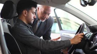 Genç adam bir showroom 4 k yeni bir araba incelenmesi