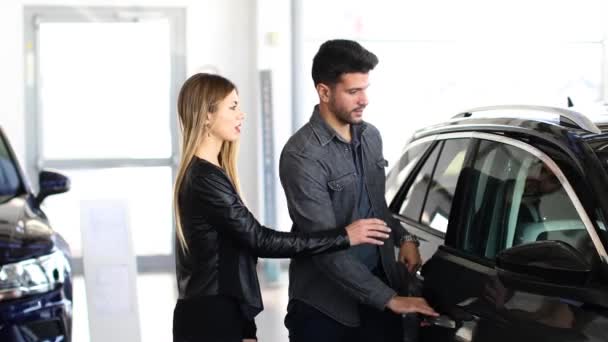 Pareja Joven Eligiendo Coche Nuevo Para Comprar Tienda Concesionarios — Vídeos de Stock