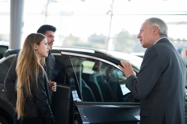 Feliz Joven Familia Hablando Con Vendedor Elección Nuevo Coche Una — Foto de Stock