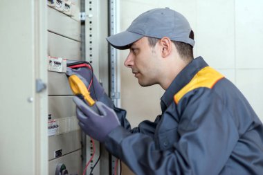 Bir test eden bir fabrikada endüstriyel bir panelde kullanarak iş yerinde elektrikçi
