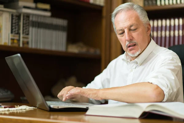 Uomo Che Usa Suo Portatile Mentre Legge Libro — Foto Stock