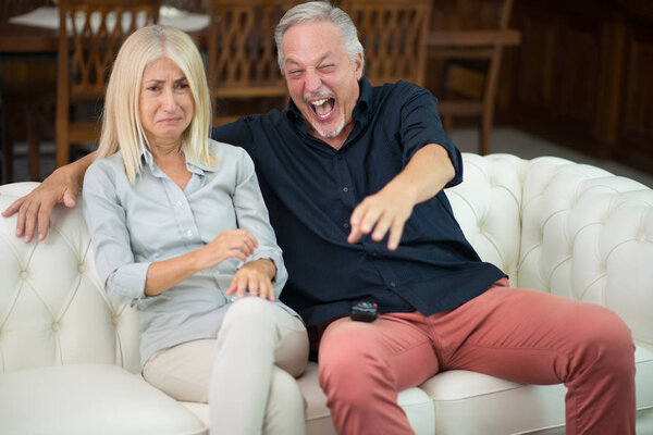 Man having a good laughter while his wife cries