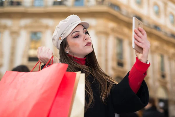 Mujer Joven Usando Teléfono Móvil Ciudad Mientras Lleva Bolsas Compras — Foto de Stock