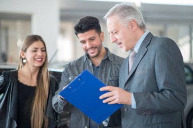 Müşterilerle konuşurken araba satıcısı 