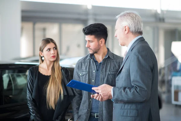 bir araba satıcısı bir salon araba seçimi Çift