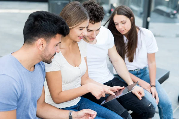 Ομάδα Νέων Φίλων Χρησιμοποιώντας Ένα Tablet Μαζί Ενώ Κάθεται Ένα — Φωτογραφία Αρχείου