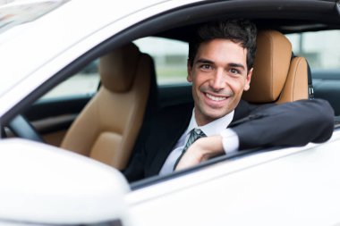 Yakışıklı adam arabasını kullanıyor.