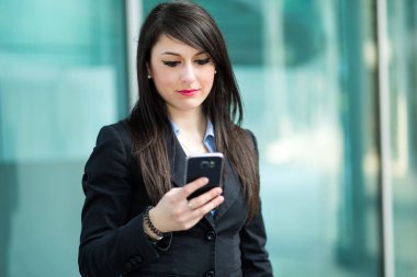 Açık bir smartphone kullanarak gülümseyen iş kadını