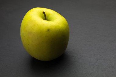 Koyu arkaplanda sarı elma