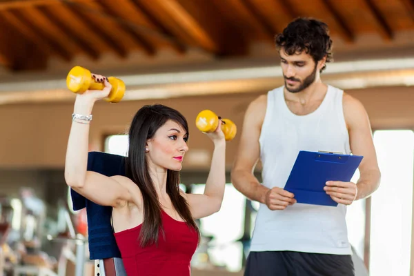 Kobieta Zniesienie Dumbbells Instruktorem — Zdjęcie stockowe