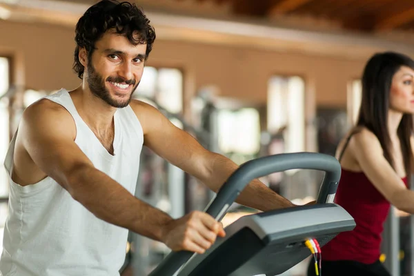 在体育馆里锻炼腿的男人骑自行车做有氧运动 — 图库照片
