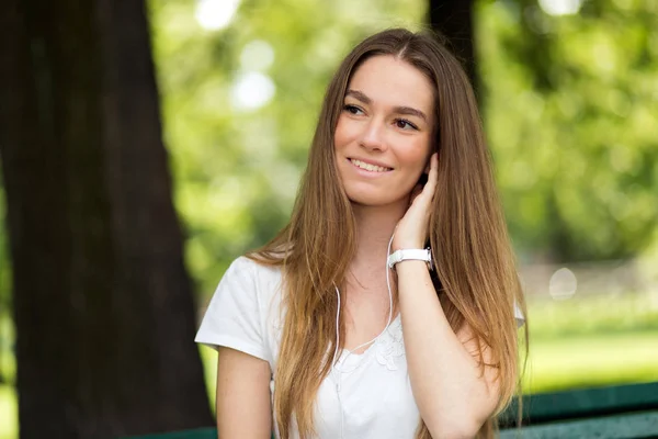 Vrouw Luisteren Naar Muziek Zittend Een Bank Een Park Een — Stockfoto