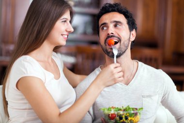 oturma odasında bir salata yemek Çift.