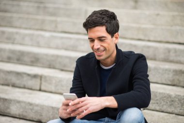 Şehir ortamında cep telefonunu kullanan bir adam