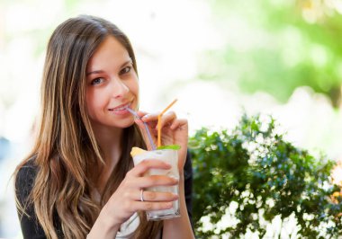 Bir barda kokteyl içen kız