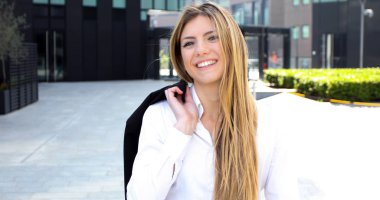 modern bir kentsel ortamda açık havada gülümseyen genç kadın yönetici