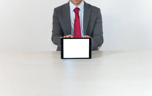 Businessman showing a blank tablet screen