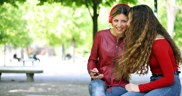 Två Vänner Lyssnar Musik Sitter Bänken Park — Stockfoto