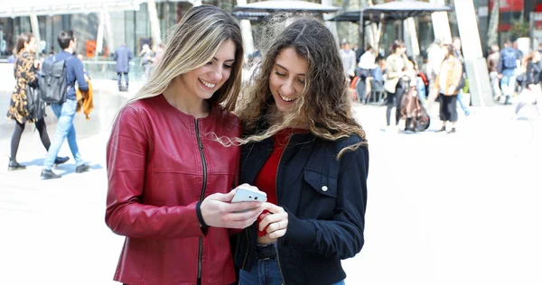 Dwa Szczęśliwe Kobiety Przyjaciele Patrząc Smartphone Odkryty — Zdjęcie stockowe