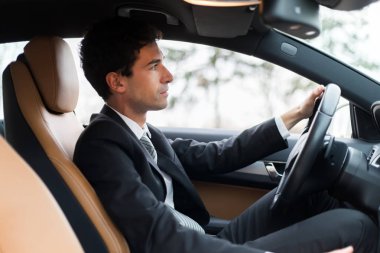 Yakışıklı adam arabasını kullanıyor.