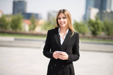 İş kadını cep telefonunu kullanıyor.