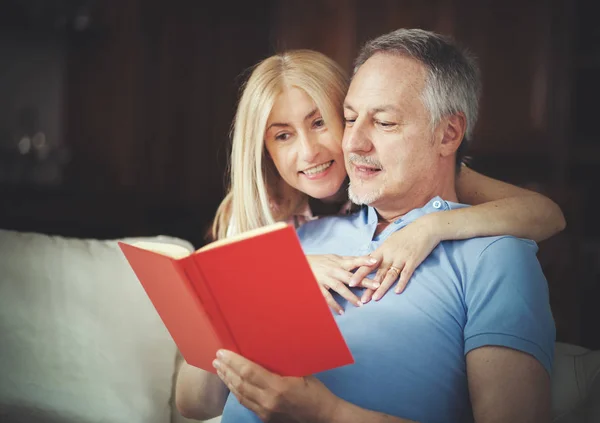 Happy mature couple reading a book