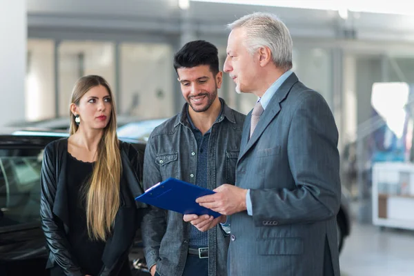 Happy Young Family Talking Salesman Choosing New Car Showroom — Stock Photo, Image