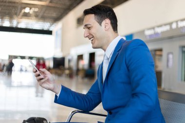 Havaalanındaki telefonu kullanan bir iş adamı.
