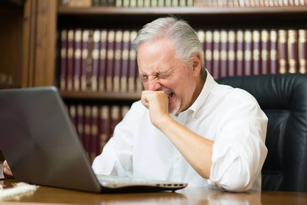 Üzletember Használ Laptop Egy Könyvtárban Miközben Tüsszőlő Vagy Tátongó — Stock Fotó