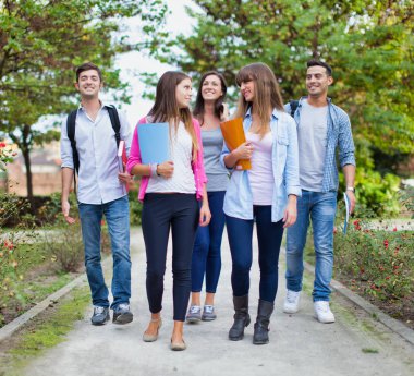 Okul parkında yürüyen bir grup öğrencinin açık hava portresi
