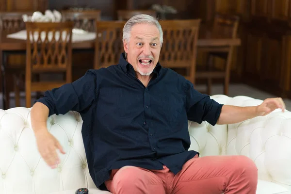 Man watching a sport match in his television