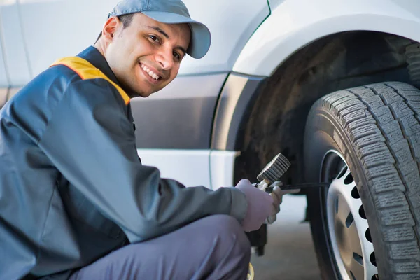 Smiling Mechanic Inflating Van Tire — Stock Photo, Image