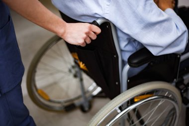 Yaralı bir hasta üzerinde bir tekerlekli sandalye iterek hemşire