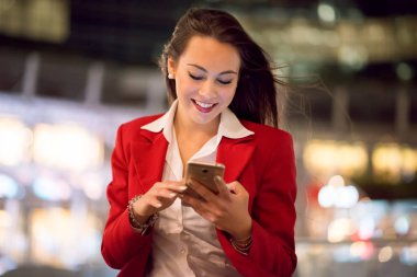 İş kadını büyük bir şehirde gece açık havada cep telefonu kullanarak