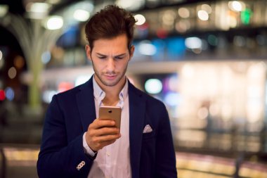 Genç adam geceleri yürürken cep telefonunu kullanma