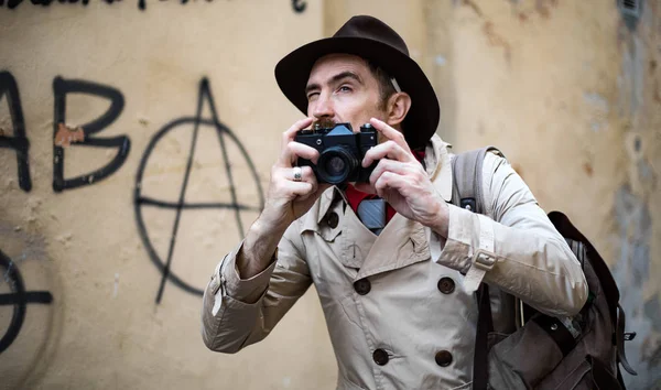 Detective taking pics in a city slum with his vintage camera