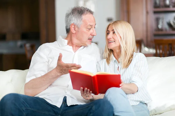Mature couple reading a book together