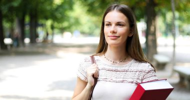 Parkta kitap tutan kız öğrenci