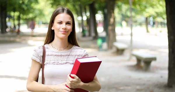 面带笑容的女学生 拿着本书 — 图库照片