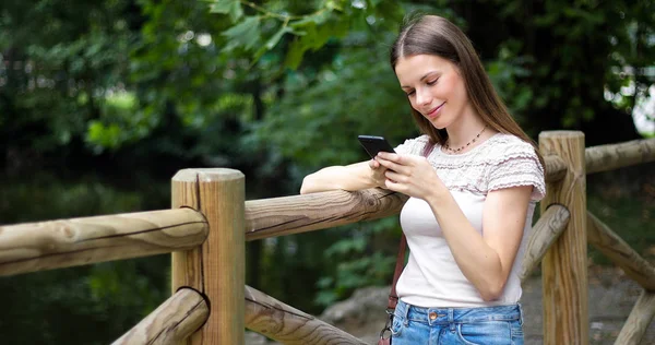 Parkta Akıllı Telefonunu Kullanan Genç Kadın — Stok fotoğraf